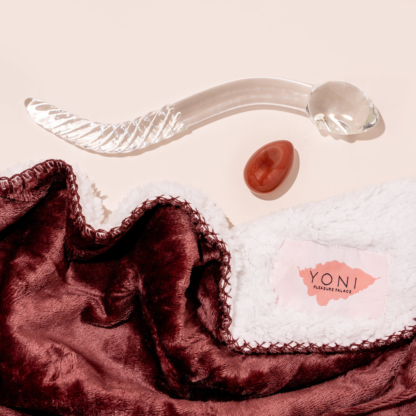 Cervix Moon kit includes waterproof blanket in moon blood red, red carnelian crystal yoni egg and clear glass cervix serpent pleasure wand. 