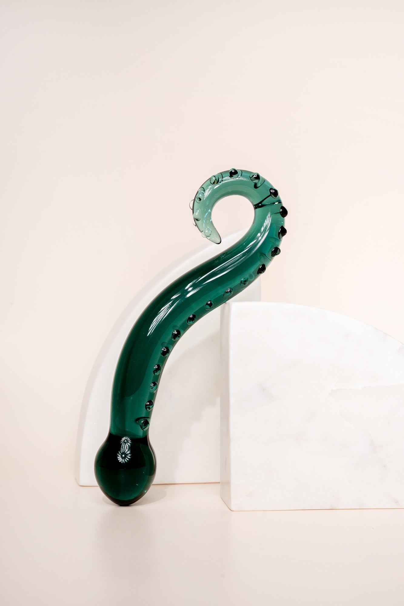 Dark green coloured glass pleasure wand (Octopussy). Pictured on white background with marble coloured arch blocks.
